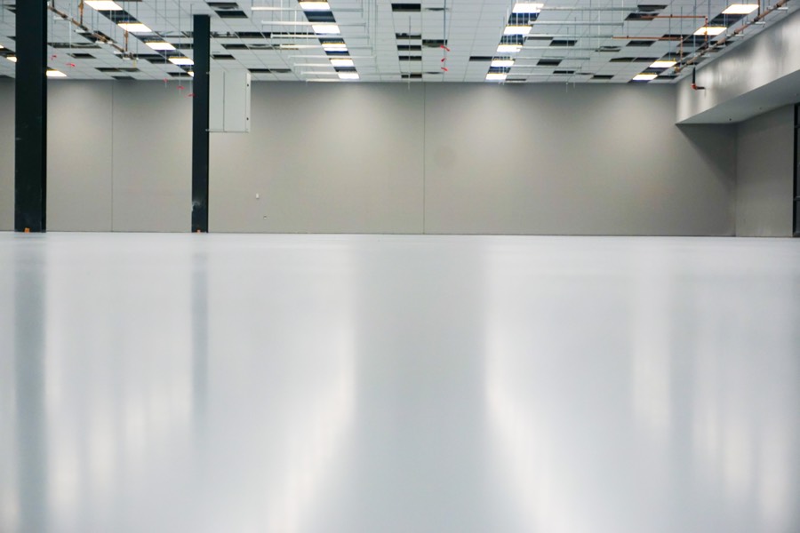 Seamless ESD floor system meeting the facility wall line